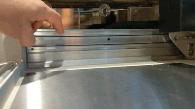 Animated GIF of a finger pressing on the side belt in a Glowforge. When one side is pressed, the other doesn't move.